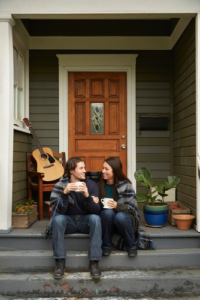 Young couple sitting on porch step chatting
