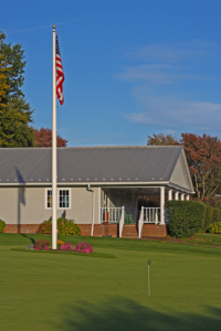 an American rural home with a flag pole displaying the United States flag