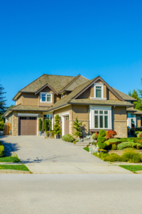 Big custom made luxury house with nicely landscaped and trimmed front yard and driveway to garage in the suburbs